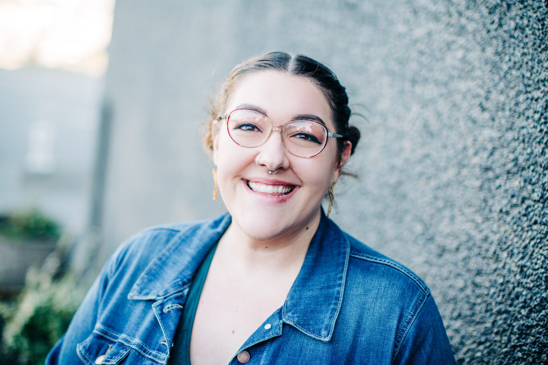 Head shot of Joey Joseph, Tacoma Youth For Christ Claudia Thomas Middle School Campus Life Site Leader. Joey stands smiling in front of a dark gray outdoor wall.