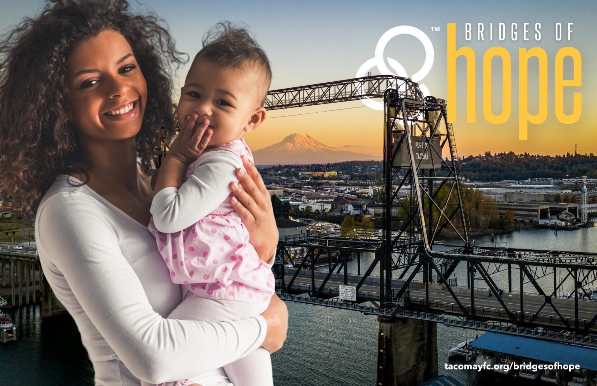 Teenager Bailee holding her baby daughter in front of a backdrop of Tacoma's Murray Morgan Bridge at sunrise.