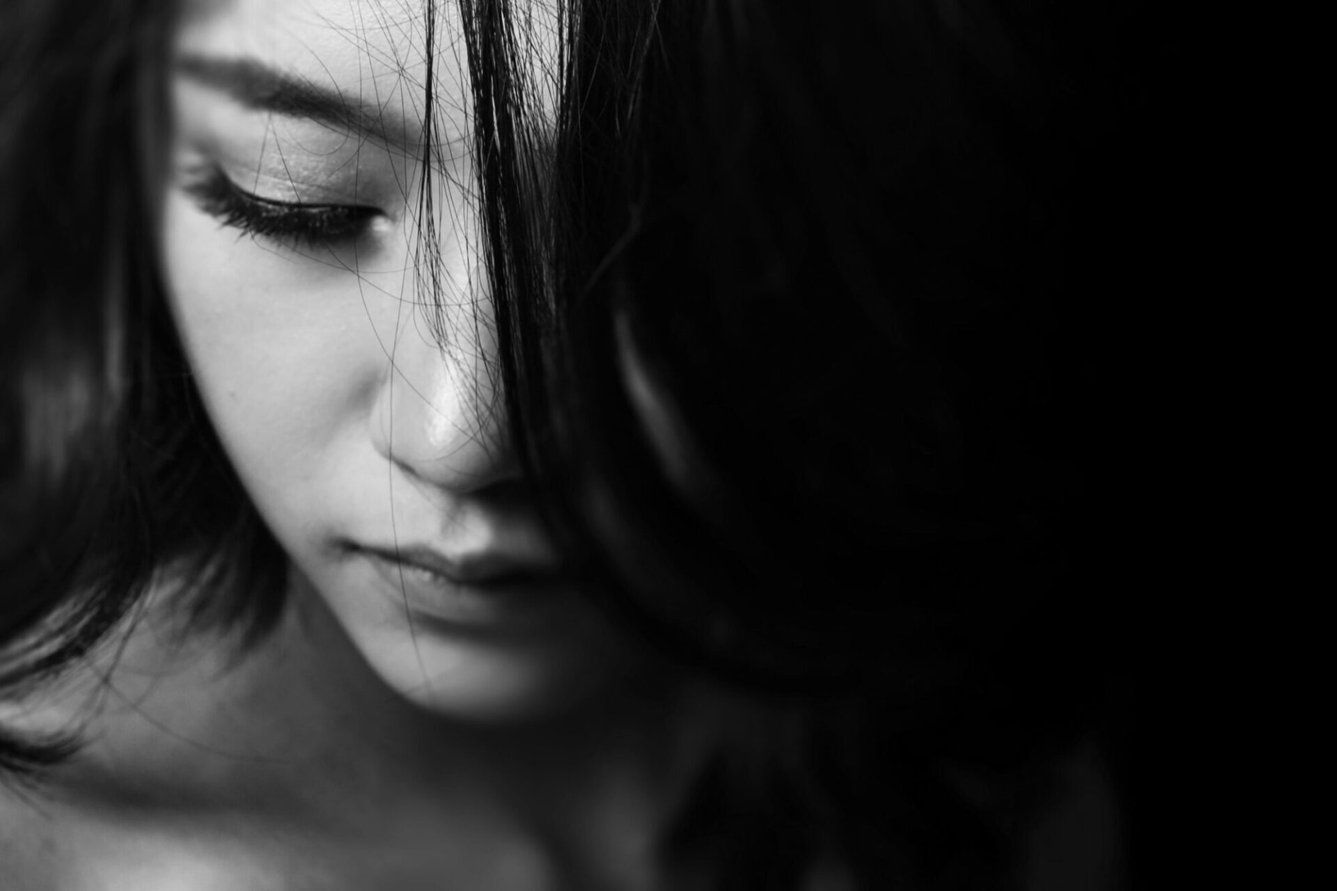 Black and white headshot of a girl looking down and to the left.